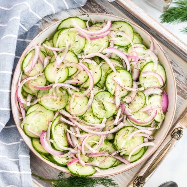 cucumber salad in a serving bowl on tray