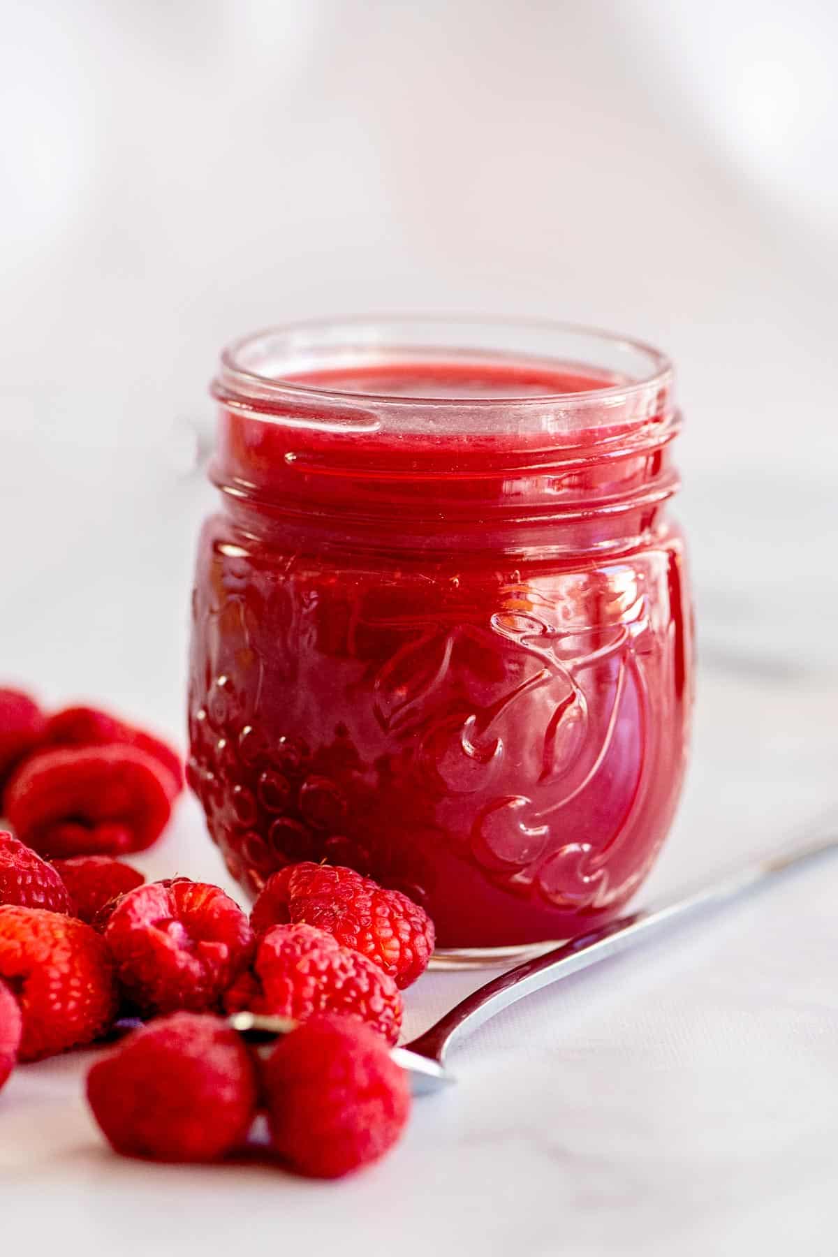 raspberry sauce in jar from side.