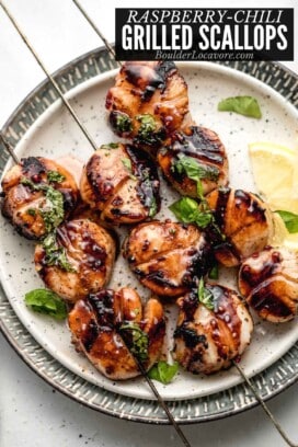 grilled scallops on skewers on plate with lemon.