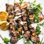 plate of greek steak kebabs with yogurt dipping sauce crop.