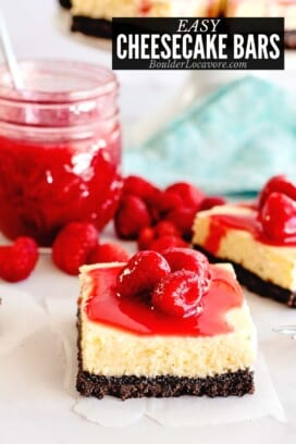 cheesecake bars close up with raspberry sauce.
