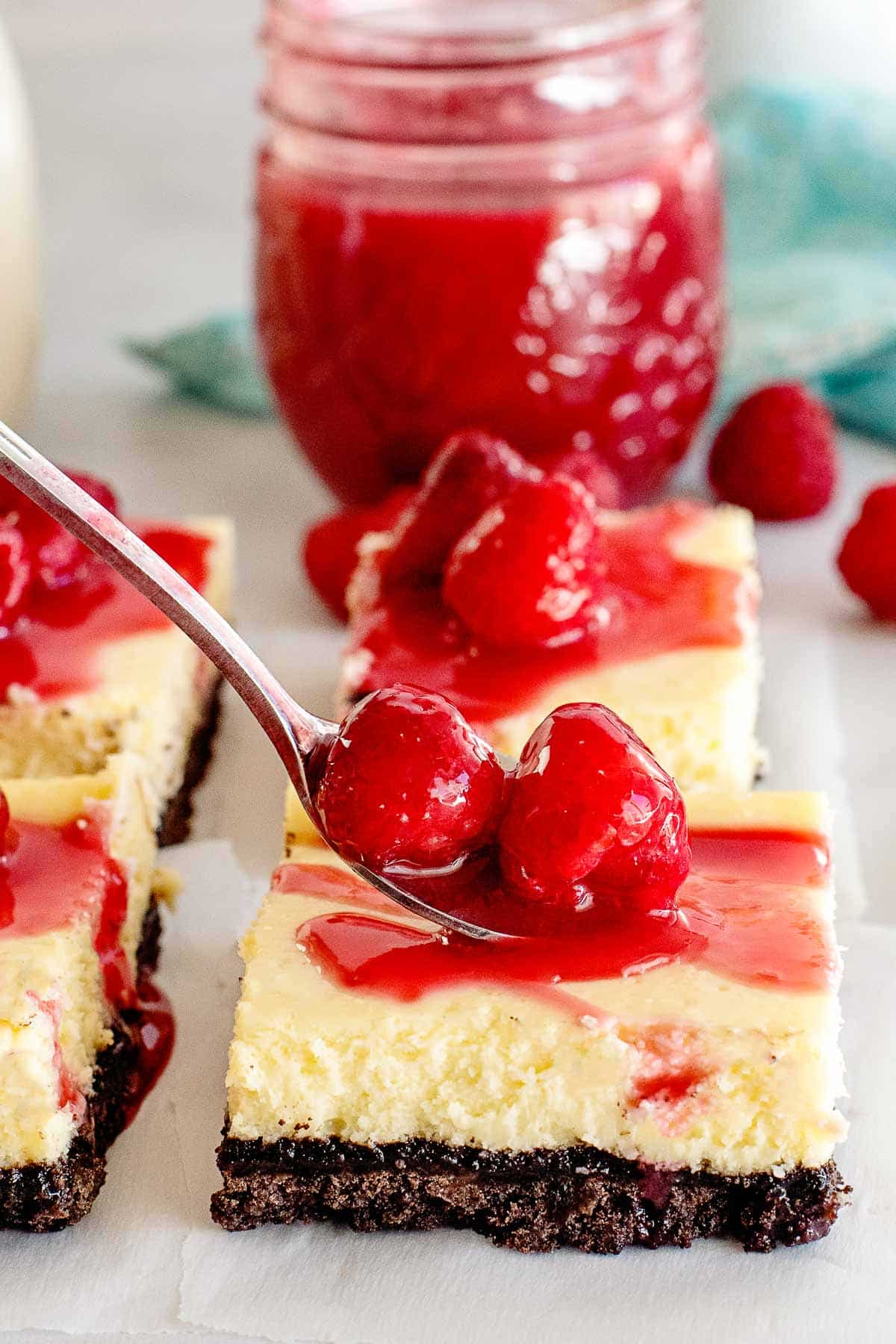 cheesecake bars with fresh raspberries on top.