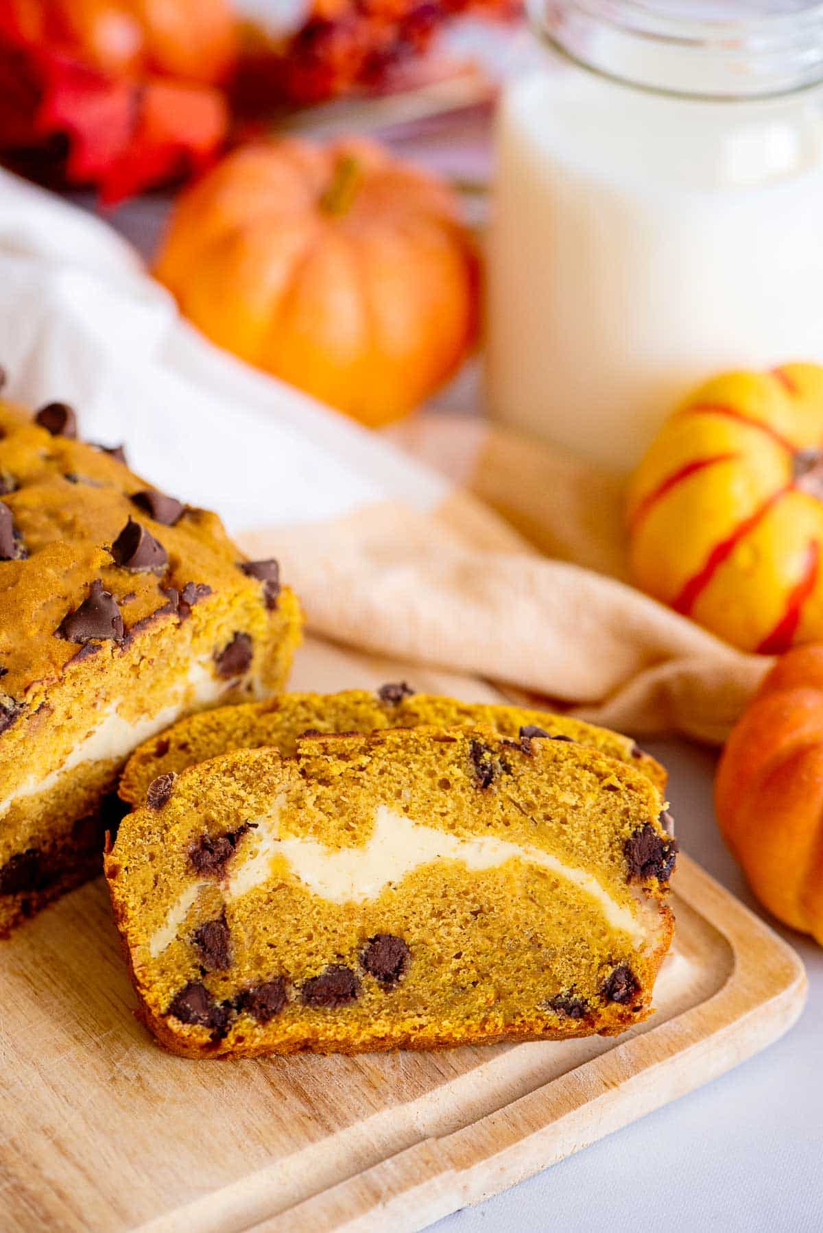 pumpkin chocolate chip bread sliced loaf with glass of milk.