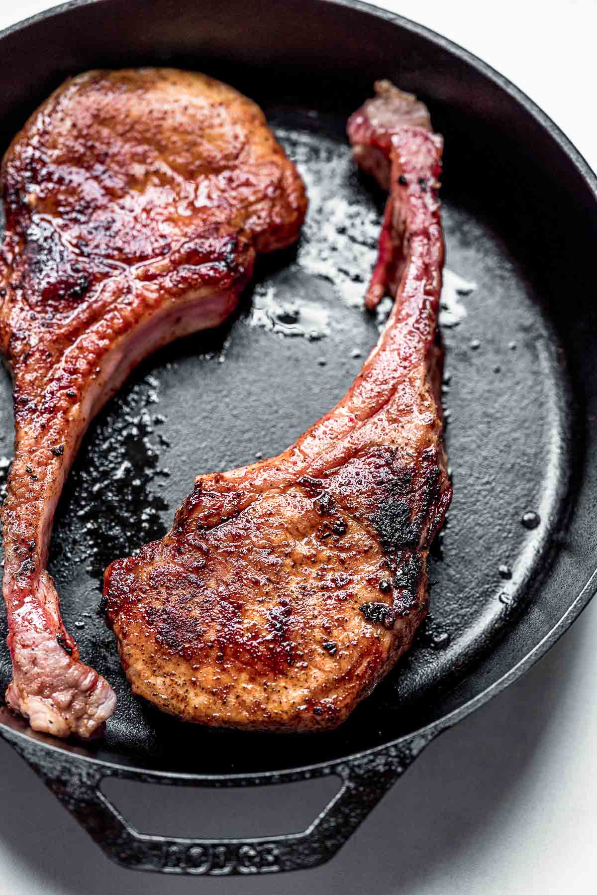 pan seared pork chops seared in skillet.