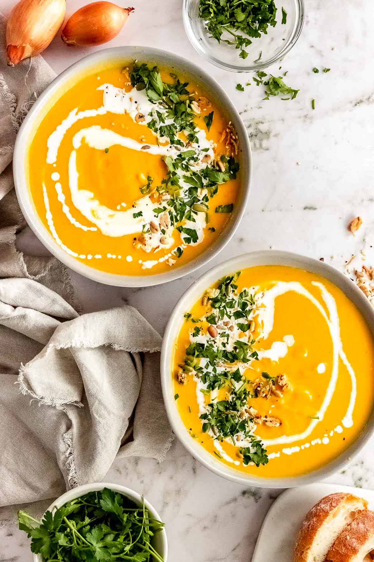 slow cooker pumpkin soup in bowls with garnish overhead.