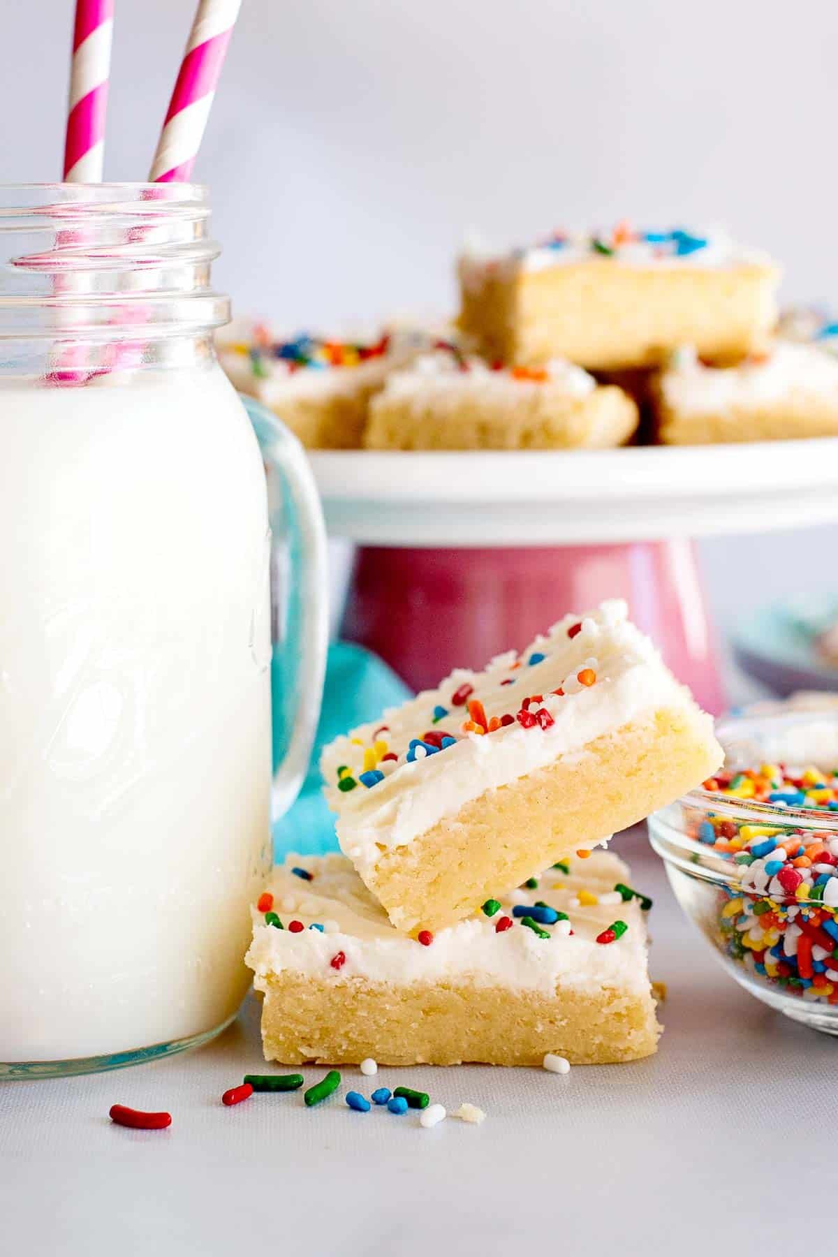 stacked sugar cookie bars stacked with milk.