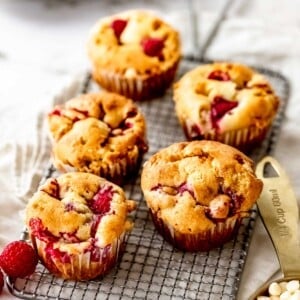 white chocolate raspberry muffins on a wire rack.