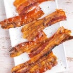 candied bacon on white platter.