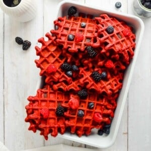Red velvet waffles topped with different berries.