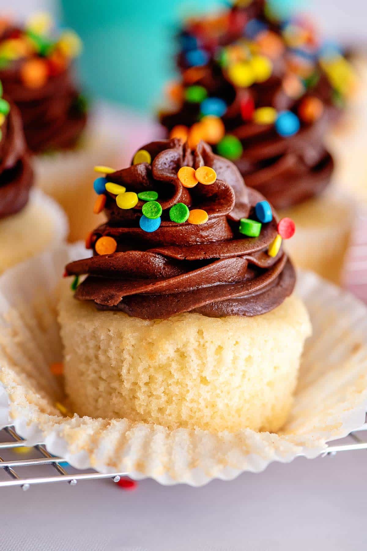 yellow cupcakes with chocolate frosting liner peeled