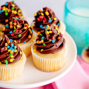 yellow cupcakes with chocolate frosting on cake pedastel cropped