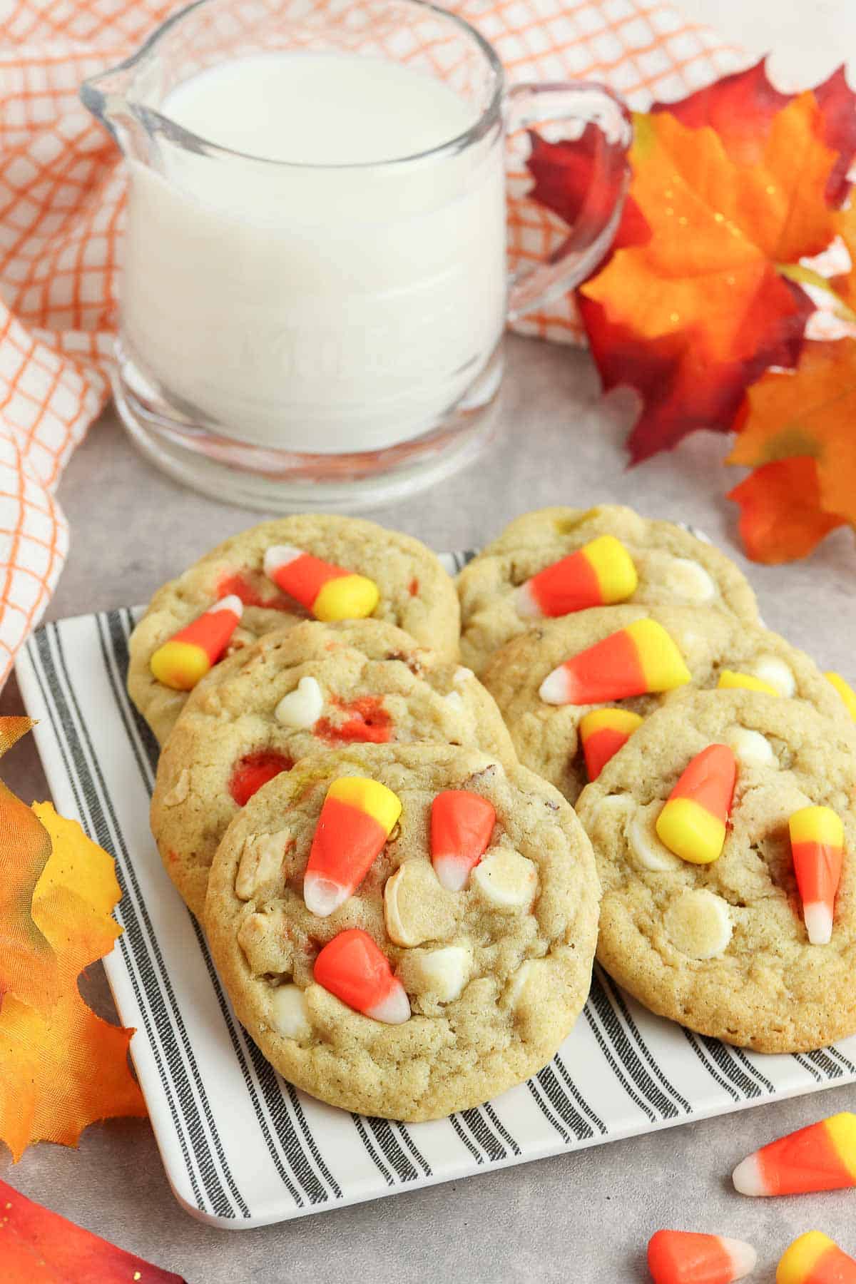 candy corn cookies on plate with milk pitcher.