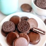 chocolate covered oreos on white plate with milk jar.