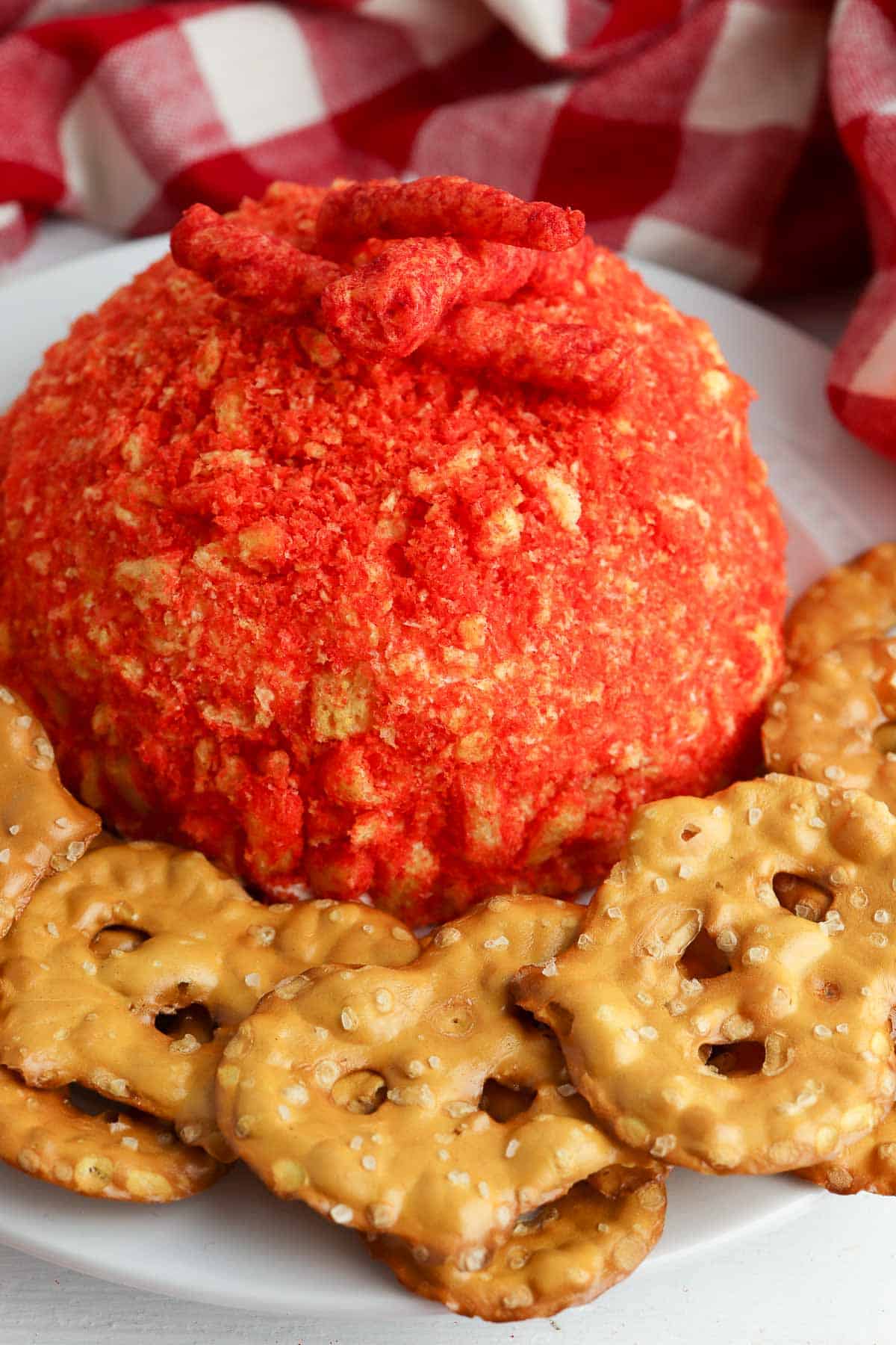 spicy cream cheese ball with pretzel crackers on plate.