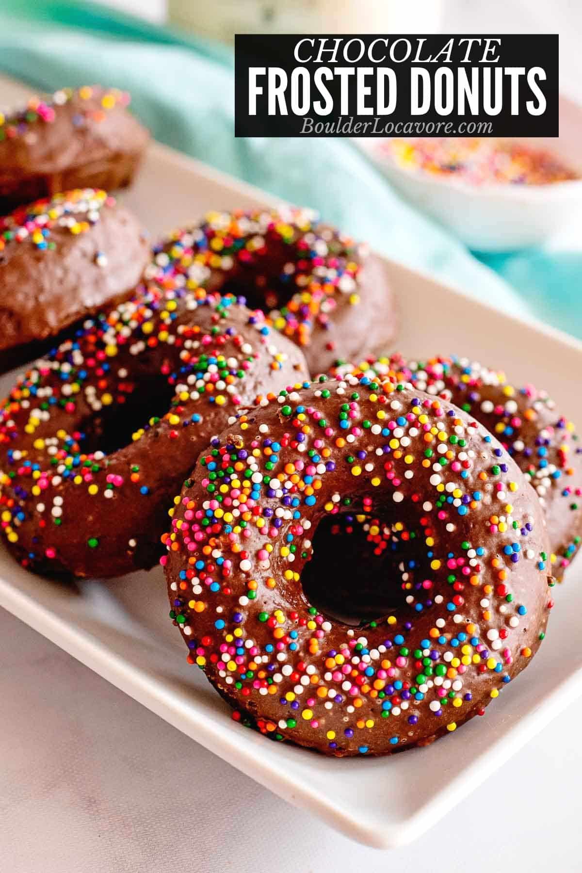 chocolate frosted donuts on a white serving plate.