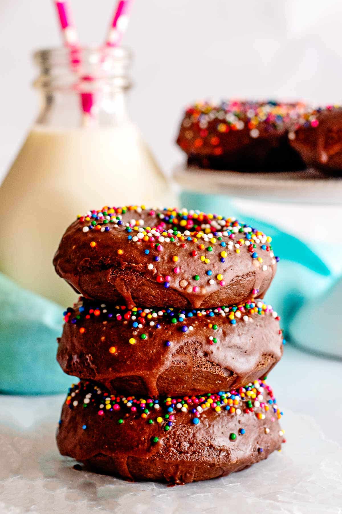 chocolate glazed donuts with sprinkles stacked.