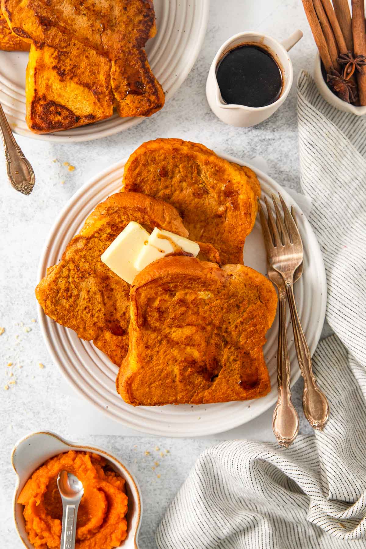 pumpkin french toast on plate with syrup and butter.
