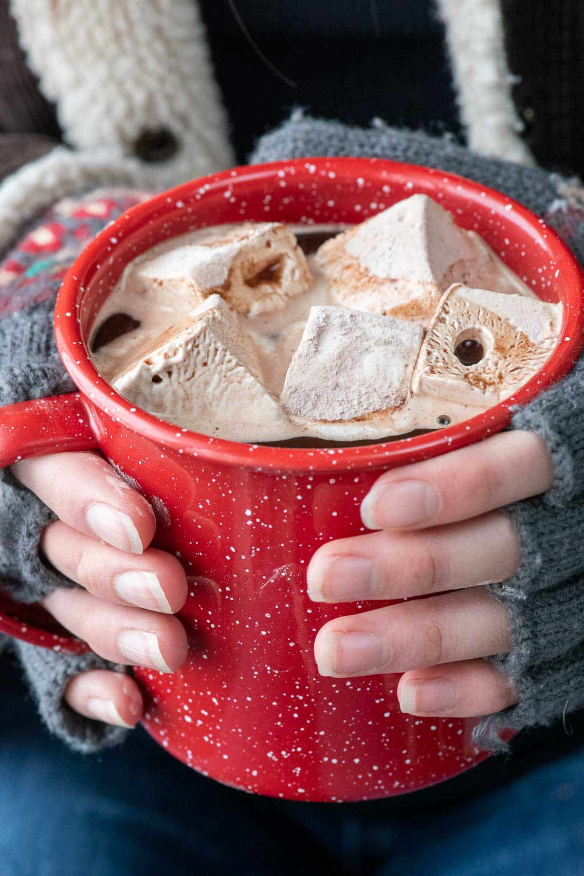 red enamel cup wtih hot chocolate and marshmallows.