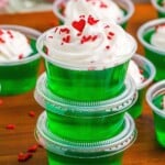 Grinch Jello Shots stacked with whipped cream.