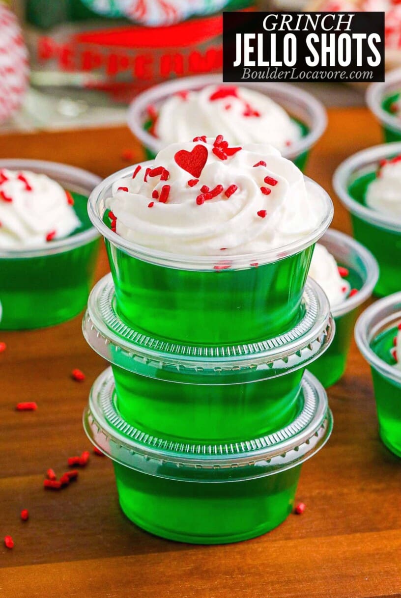 Grinch Jello Shots stacked with whipped cream.