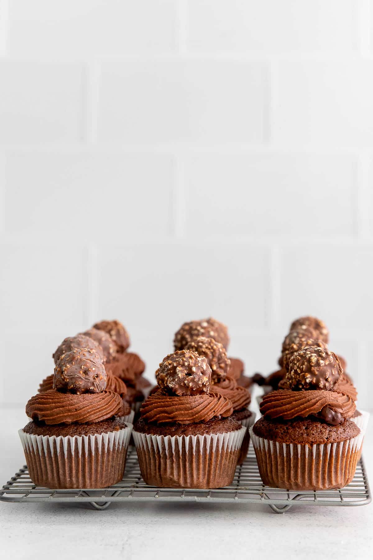 ferrero rocher cupcakes on a metal cooling rack side view.
