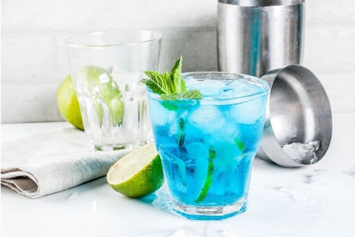 Blue Margarita in a glass with cocktail shaker