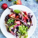 Strawberry Salad with Strawberry Poppy Seed Dressing on a white plate with recipe title