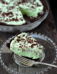 Single slice of Grasshopper Pie recipe on a plate with whole pie in background