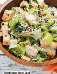 Wooden bowl of Grilled Chicken Caesar Salad with light creamy dressing