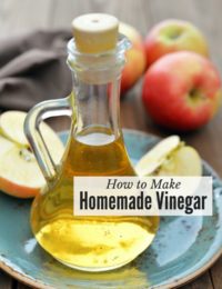 Carafe of apple cider vinegar with apples (titled image of how to make homemade vinegar)